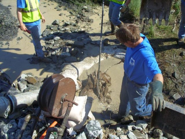 More roots and mud  removed from the pipe.  The vac truck (the pipe to the left) is removing the water with the highest concentration of sediment.  